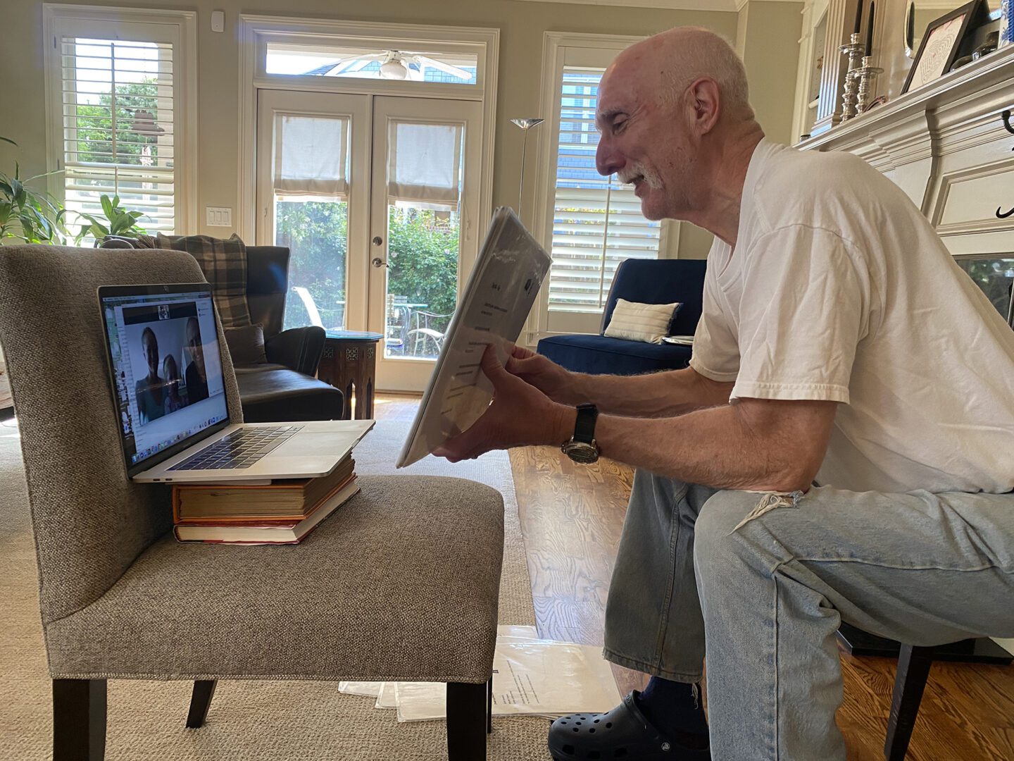 A man sitting on the floor in front of a laptop.